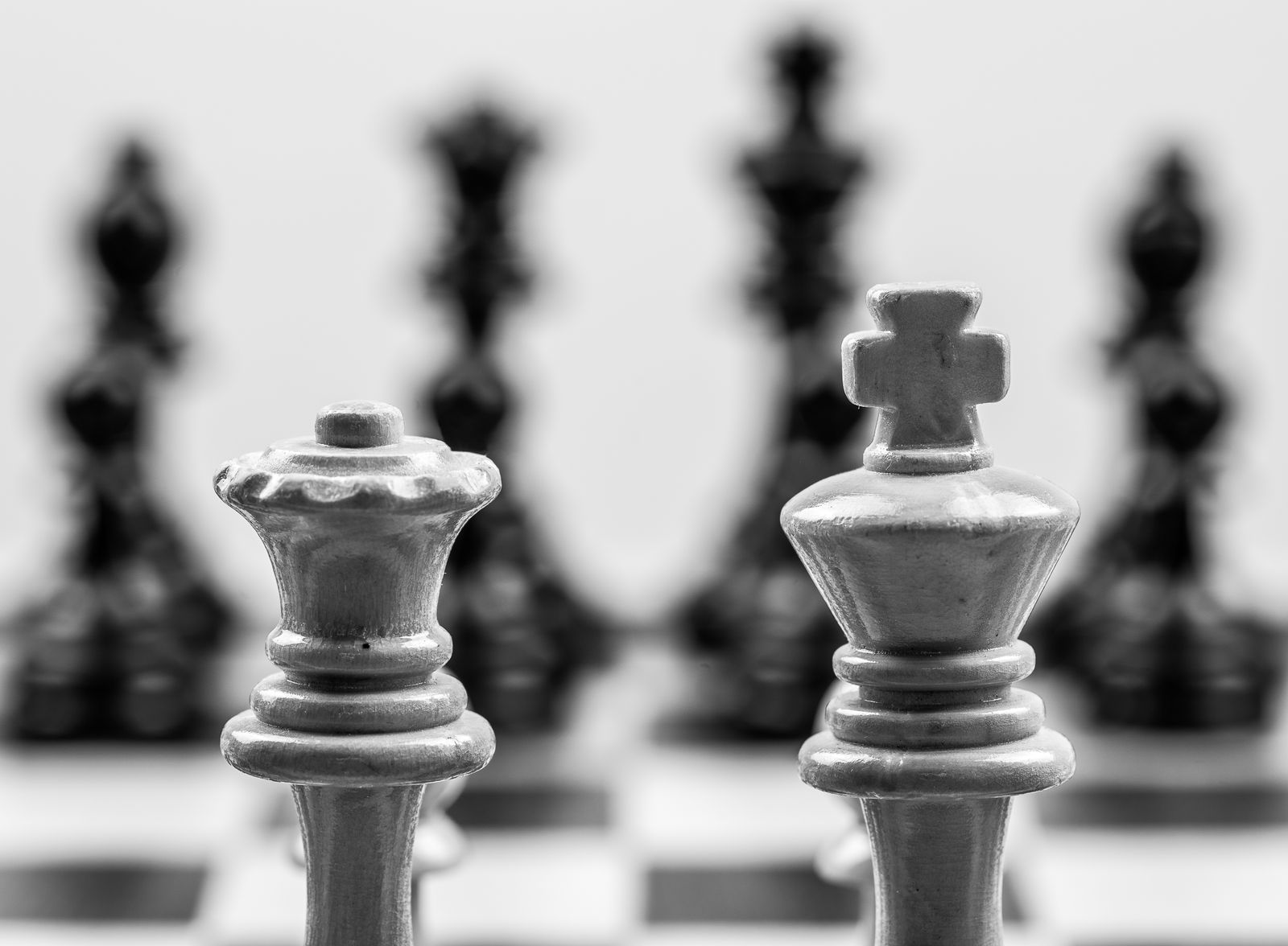 Close-up of a king and queen chess piece on a board