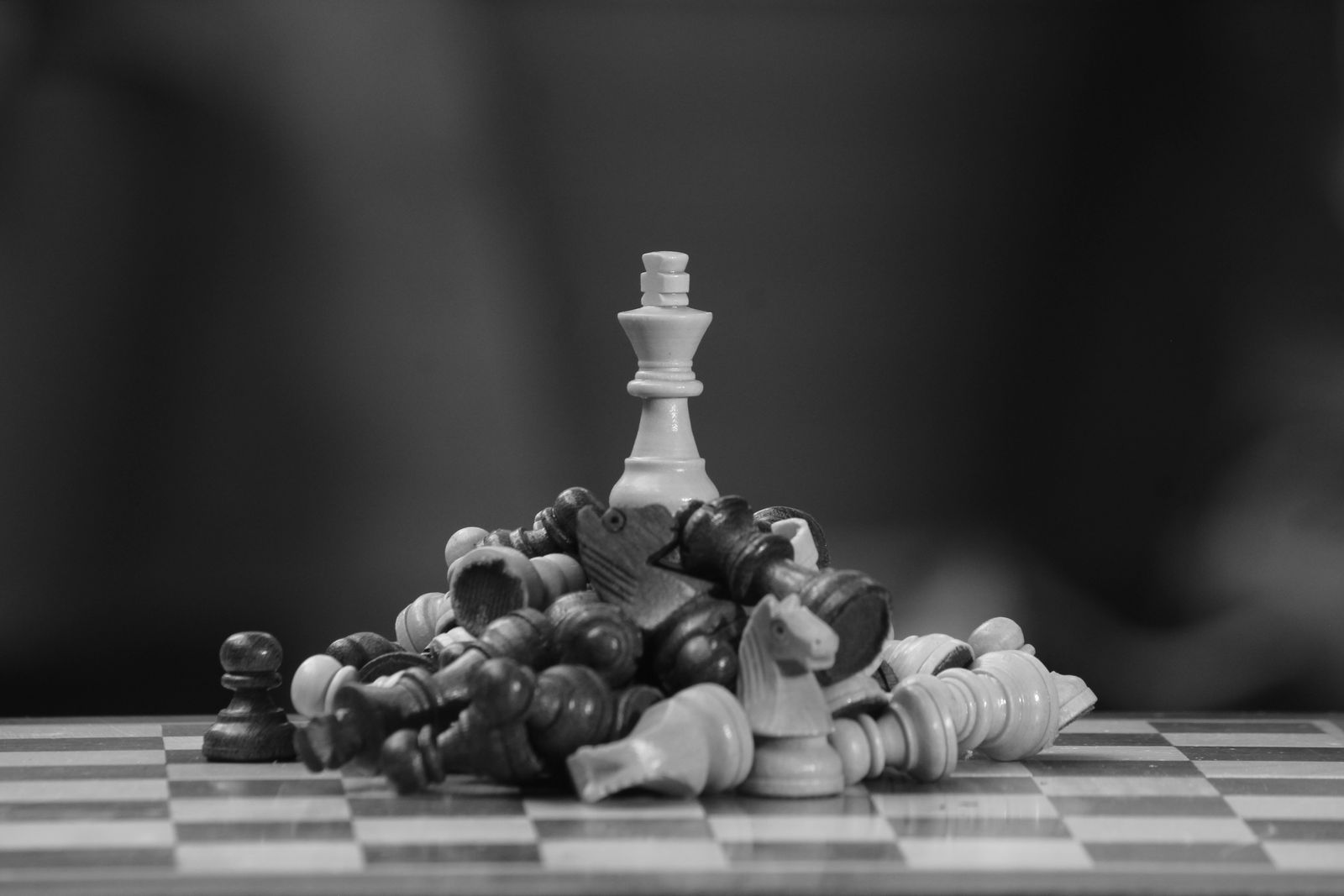 Chess king standing among fallen pieces, representing the endgame technique that decides Ju Wenjun's games